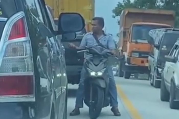 Aksi pemalakan oleh preman kampung naik Honda BeAT ke tiap mobil terjebak macet di Jalan Raya Sumbar-Riau, Pangkalan, Lima Puluh Kota, Sumatera Barat