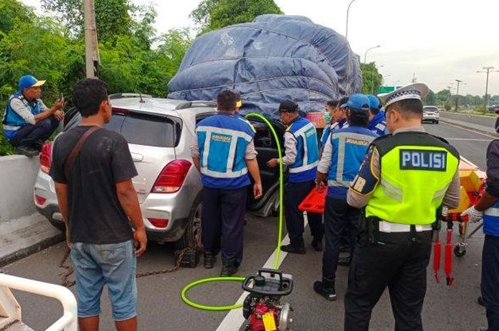 Petugas berusaha mengevakuasi sopir Chevrolet Trax yang sosor truk trailer di tol arah Bandara Soekarno-Hatta