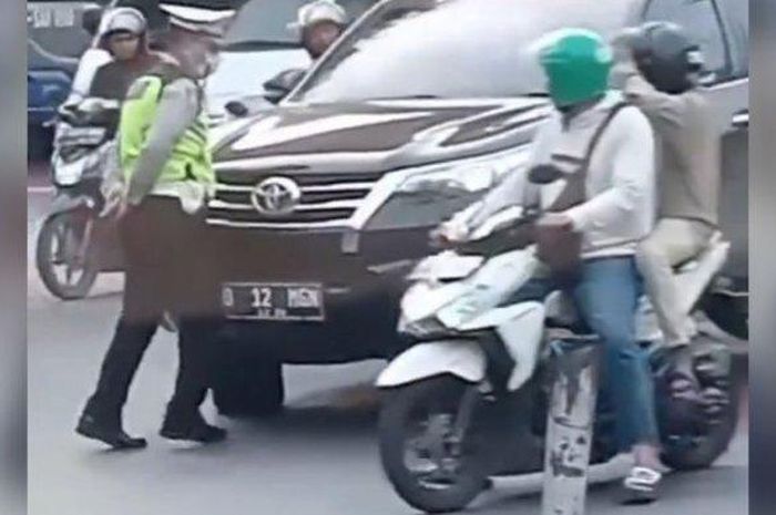 Pihak berwajib yang menghalangi laju Toyota Fortuner karena melanggar lalu lintas.