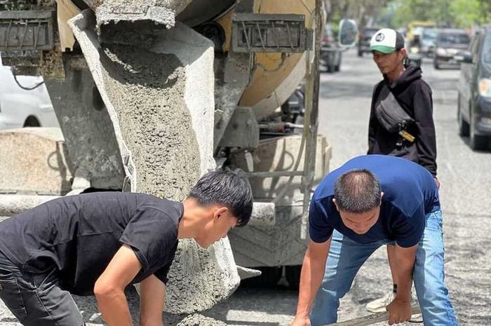 Pengusaha asal Kota Pekanbaru, Bambang (kaus biru) ikut turun melakukan perbaikan jalan berlubang di wilayah Kota Pekanbaru.