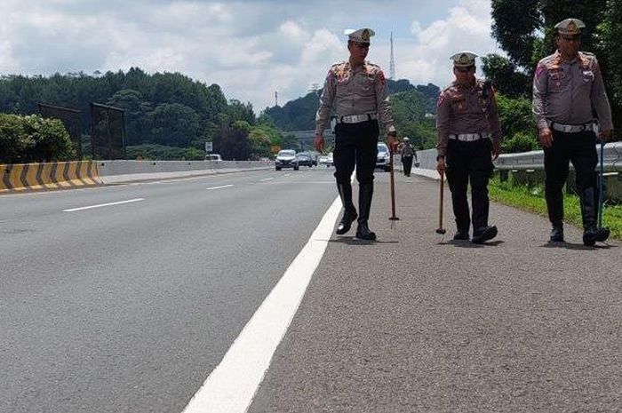 Anggota Satlantas Polres Cimahi menyisir ranjau paku di ruas tol Purbaleunyi, Jawa Barat, dapat seember paku sampai silet