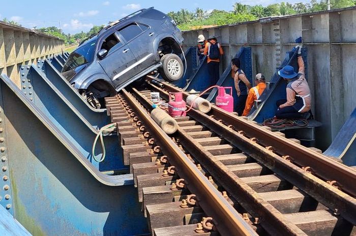 Proses evakuasi Toyota Fortuner kejepit di jembatan rel kereta api akibat disengaja sopir yang mengajak seluruh penumpang mati