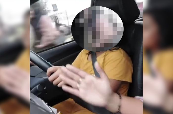 Cuplikan video anak di bawah umur diajari menyetir mobil di jalan raya.