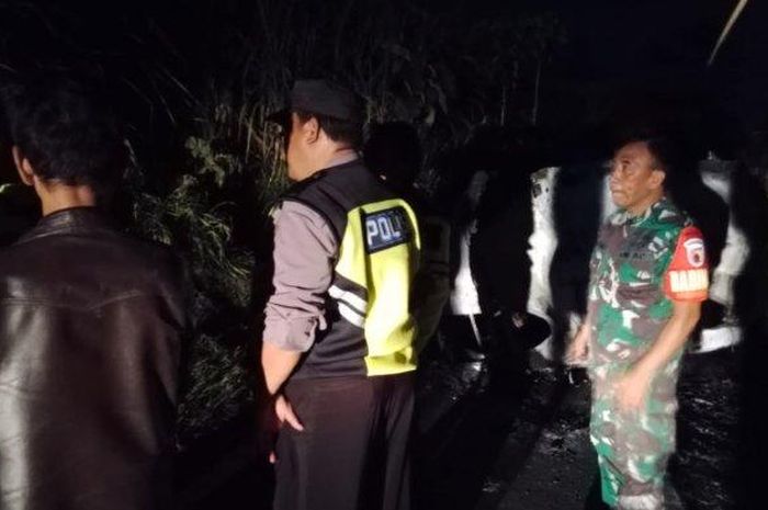 Polisi dan TNI amankan TKP Toyota Calya terbakar di jalan raya dusun Jatiarjo, desa Gunung, Jabung, kabupaten Malang