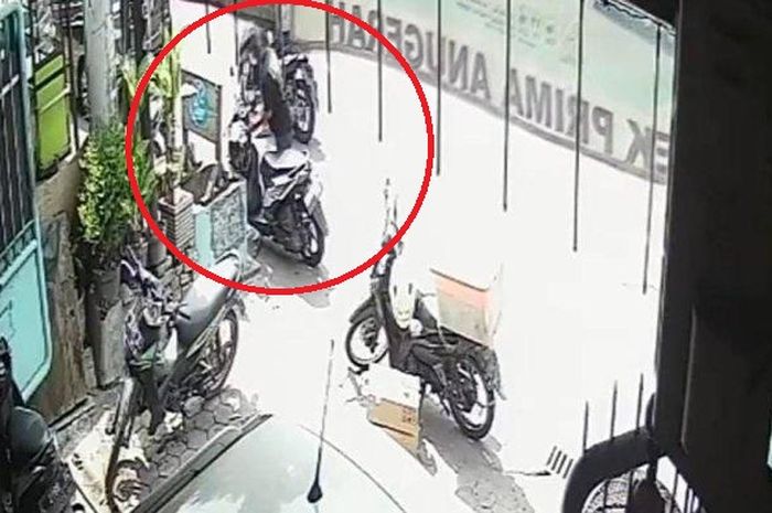 Dalam lingkaran merah, pelaku maling menggondol Honda BeAT posisi dikunci setang hanya dalam waktu 18 detik di parkiran apotek jalan raya Tandes Lor, Surabaya