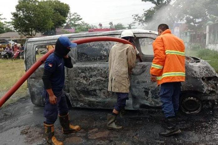 Proses pemadaman api yang membakar Daihatsu Gran Max di lapangan desa Curahpetung, Kedungjajang, Lumajang, Jawa Timur