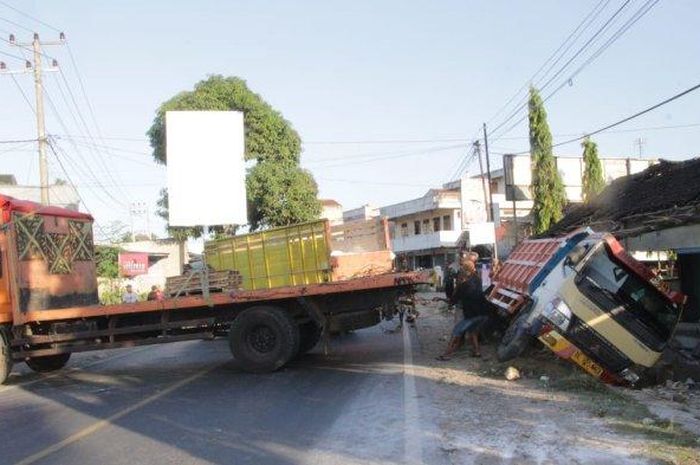 Proses evakuasi dump truck yang terjungkal ke selokan usai bikin roboh bangunan bengkel motor di Pekon Wonodadi, Gadingrejo, Pringsewu, Lampung