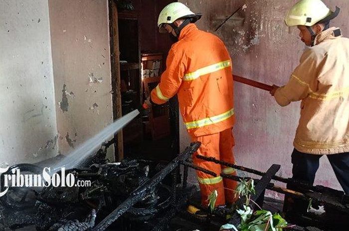 Petugas Pemadam Kebakaran memadamkan api yang membakar sebagian rumah dan Yamaha Xeon 125 milik Slamet (56) di dukuh Kutorejo, desa Plosokerep, Karangmalang, Sragen, Jawa Tengah