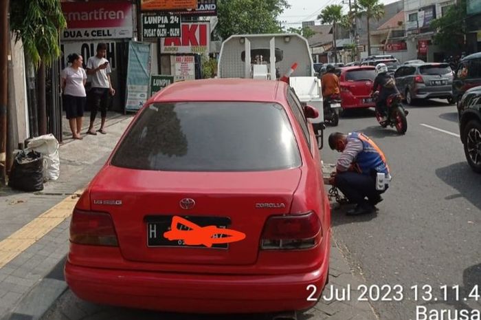 Petugas Dishub kota Semarang saat memindahkan Toyota Corolla SE-G yang 2 minggu menutup resto di Jl Kaligarang, Semarang Selatan, kota Semarang