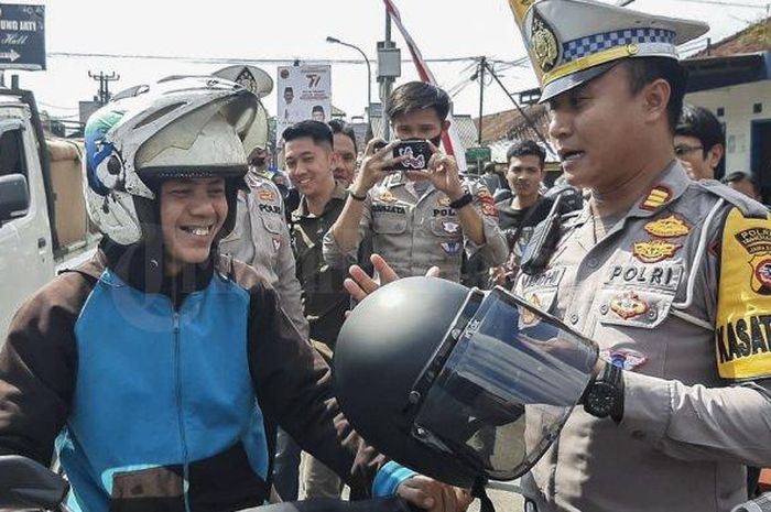 Polisi menyia helm lama mas Miftah dan menggantinya dengan helm baru saat Operasi Patuh Lodaya 2023 di Tasikmalaya
