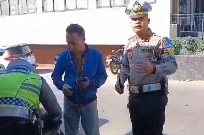 Polisi menilang pemotor lawan arah di perlintasan kereta Jl Tujuh Pahlawan Revolusi, Karawang, Jawa Barat