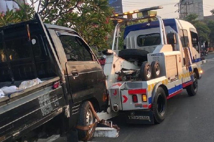 Suzuki Carry pikap diderek truk Dishub Surabaya usai terguling di dekat taman Pelangi, Gayungan, Surabaya