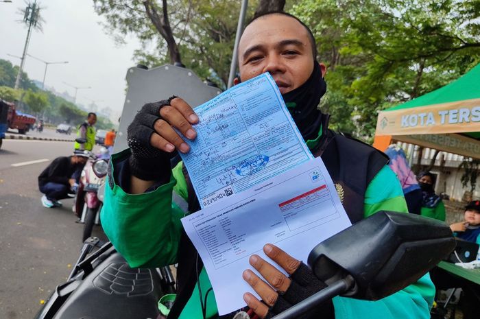 Wawan, pengendara ojek online yang terkena tilang uji emisi di lokasi razia Jakarta Pusat, Jumat (1/9/2023). 