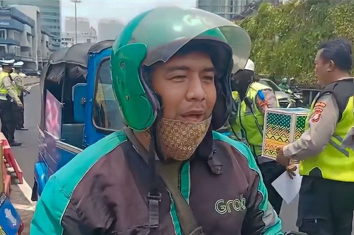 Pengojek online bernama Hendry bahagia saat kejaring razia Operasi Zebra Jaya 2023 di Tugu Tani, Menteng, Jakarta Pusat