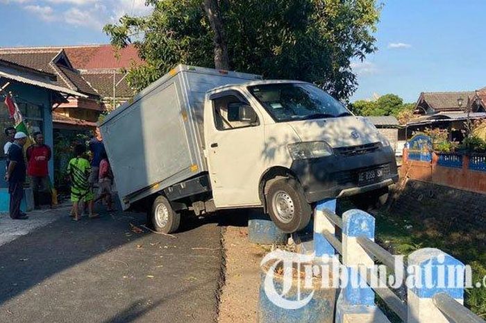 Mobil boks nangkring di atas pagar pembatas jalan