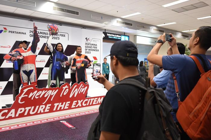 Penumpang melakukan sesi foto di booth Pertamina Grand Prix Of Indonesia 2023 di Bandara International Lombok, Lombok Tengah, Nusa Tenggara Barat pada Kamis (12/10/2023).