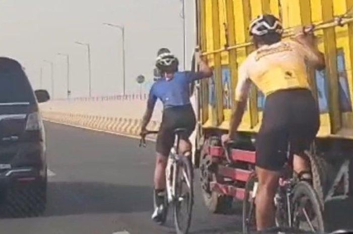 Tingkah pesepeda berpegangan pada truk saat melintasi jembatan Suramadu