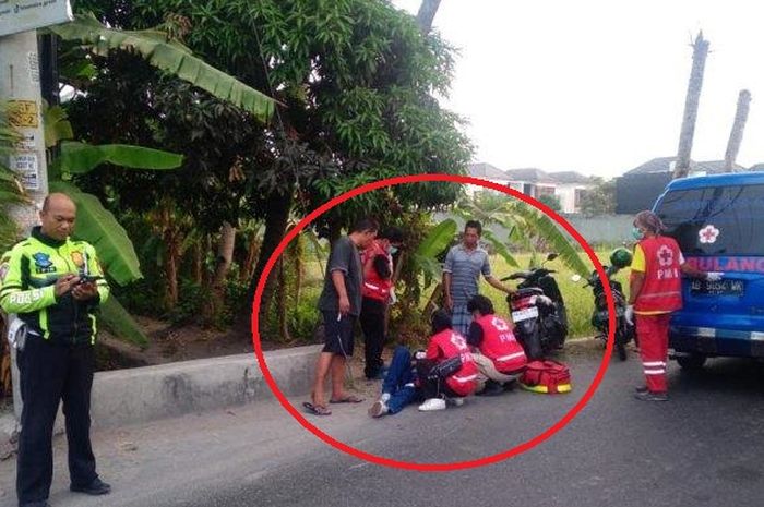 Dalam lingkaran merah pengendara Honda Scoopy tergeletak ditolong warga dan PMI usai tabrak beton tiang bendera akibat mabuk minuman keras