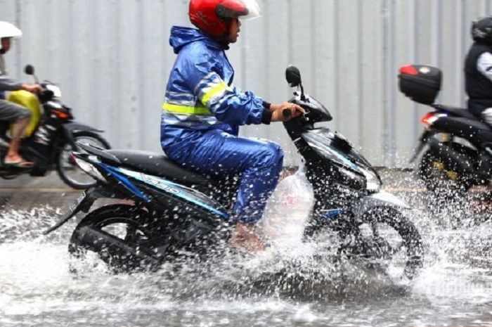 Ilustrasi pemotor pakai jas hujan.