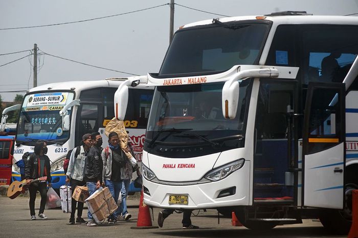 Sejumlah warga membawa barang bawaan menuju bis antar provinsi untuk mudik lebih awal di Terminal Bus Pakupatan, Serang, Banten, Kamis (23/4/2020). Meski pemerintah melarang mudik lebaran tahun 2020, sejumlah warga tetap pulang ke kampung halamannya sebelum puasa dengan alasan sudah tidak ada pekerj