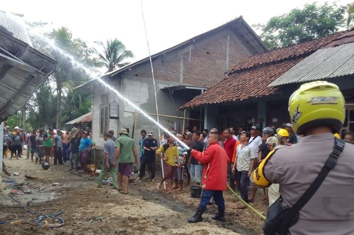 Petugas Pemadam kebakaran memadamkan api yang membakar rumah pedagang bensin eceran di desa Adisara, Jatilawang, Banyumas, Jawa Tengah