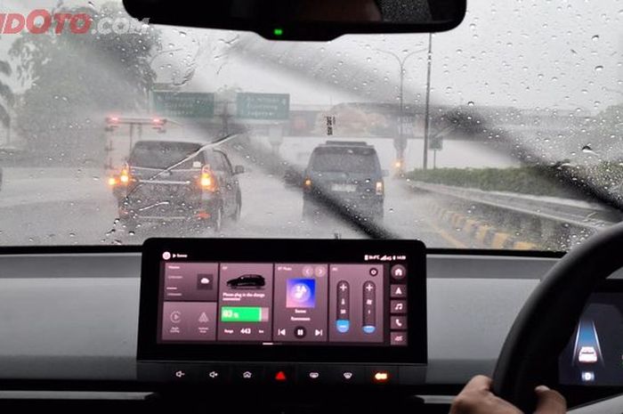 Mobil listrik dibawa berkendara saat hujan deras