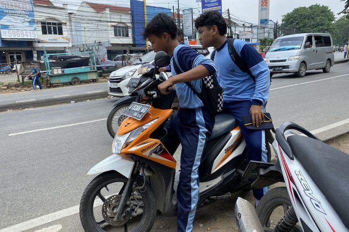Pelajar SMP di bawah umur mengendarai motor sembari merokok dan tidak menggunakan helm   
