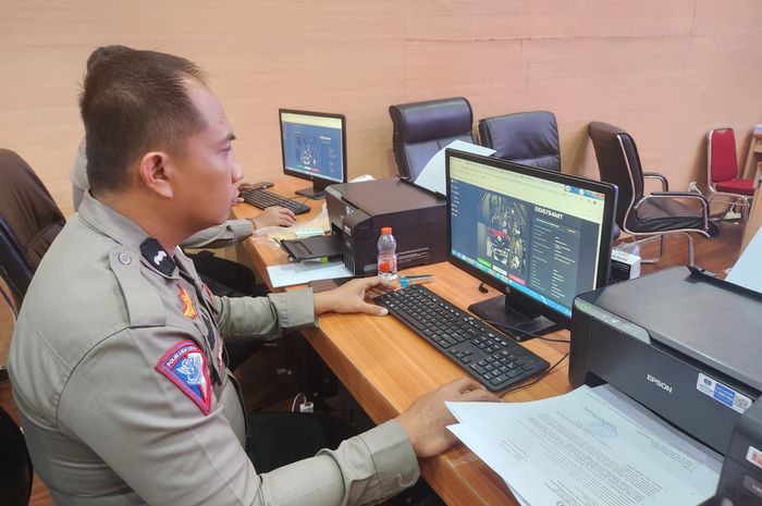 Ilustrasi anggota kepolisian melakukan pengecekan tilang elektronik