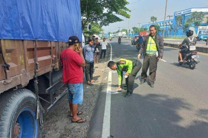 Polisi olah TKP kecelakaan truk trailer sambar tubuh Dwi Agung Lukito saat ganti ban truk tronton di tepi jalan ByPass Krian, Sidoarjo, Jawa Timur