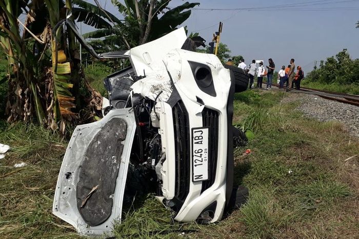 Daihatsu Ayla terkoyak di tepi rel kereta api perlintasan dusun Kaliwungu, Tarik, kabupaten Sidoarjo, Jawa Timur
