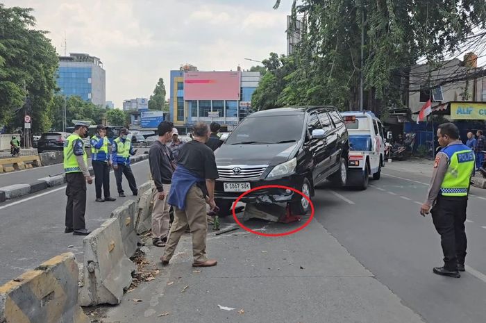Dalam lingkaran merah, beton separator busway yang tersangkut di kolong Toyota Kijang Innova di Jl Buncit Raya, Pancoran, Jakarta Selatan