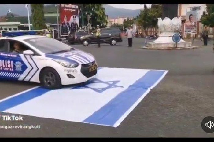 Mobil patwal Satlantas Polres Banjarnegara menginjak bendera Israel di jalan
