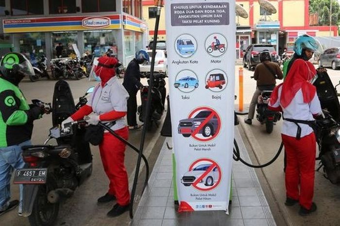 Ilustrasi petugas SPBU Pertamina melayani pengojek online beli BBM Pertalite