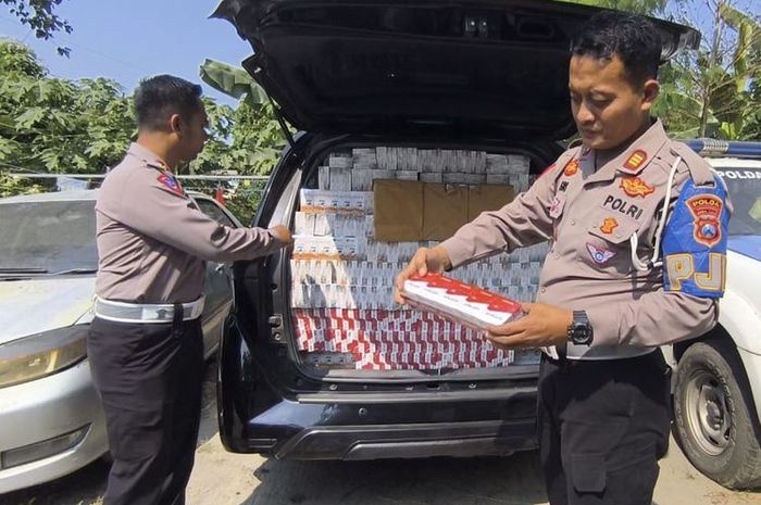 Polisi menunjukan ratusan ribu rokok ilegal tanpa cukai dari dalam kabin Toyota Kijang Innova Reborn di desa Petrah, Tanah Merah, Bangkalan, Madura