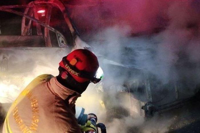 Petugas pemadam kebakaran menyemprot air ke arah Daihatsu Xenia yang sudah habis terbakar di ruas tol Bawen-Semarang KM 440