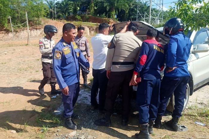 Petugas pemadam dan Polisi merubung Honda CR-V milik guru SMP Sebatik Barat, Nunukan, Kalimantan Utara karena terbakar di area mesin