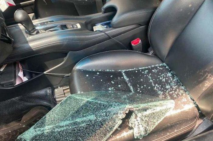 Kaca jendela pintu kiri depan Honda HR-V pecah berserakan dalam kabin saat parkir di tepi jalan raya Pakisaji, kabupaten Malang