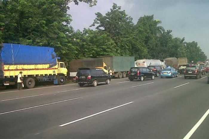 Ilustrasi truk parkir di bahu jalan tol