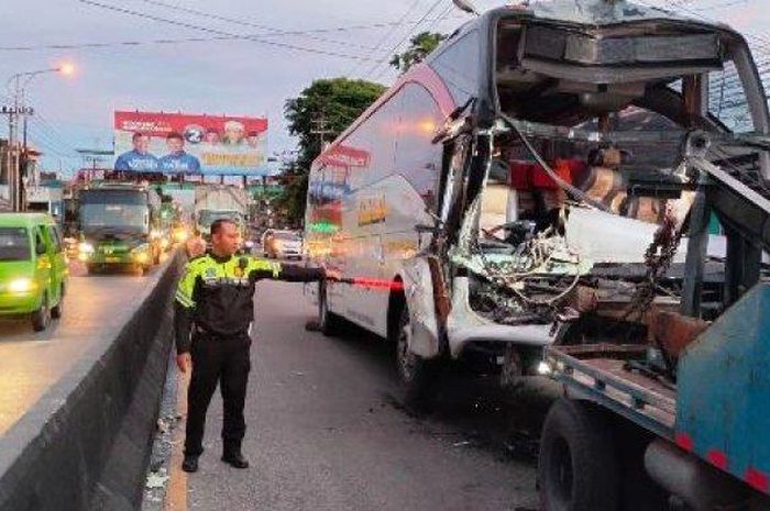 Bus PO EKA S 7517 US dievakuasi truk derek usai tabrak truk kontainer berhenti di depan pasar Babadan, Langensari, Ungaran Barat, kabupaten Semarang