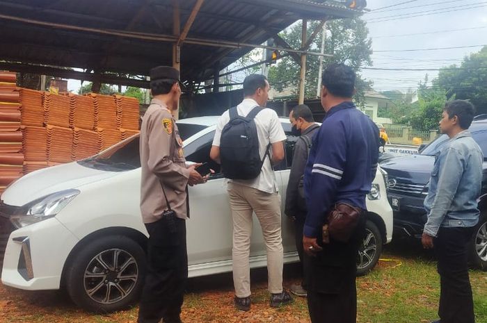 Polisi dan warga mengerumuni Toyota Agya yang menjadi korban pencurian modus pecah kaca di toko genting  Jalan Gatot Subroto, Bandarjo, Ungaran Barat, kabupaten Semarang