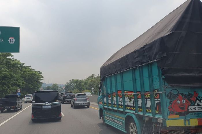 Truk medium terpantau melaju di lajur kanan jalan tol
