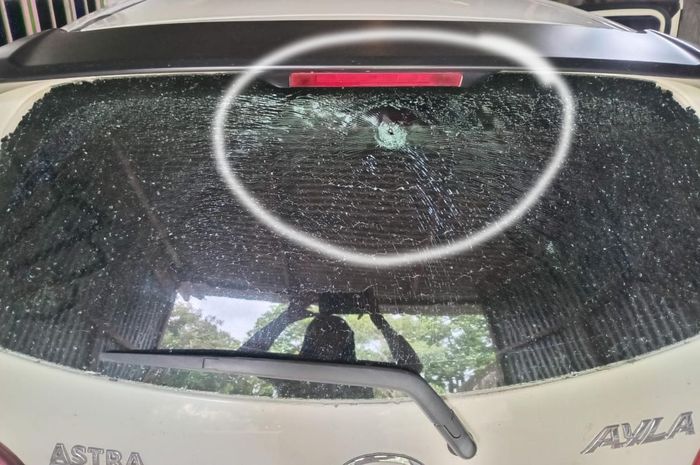 Dalam lingkaran putih, bukti lubang diduga bekas tembakan senapan angin yang mengenai kaca belakang Daihatsu Ayla milik warga desa Gayam, Gurah, Kabupaten Kediri, Jawa Timur