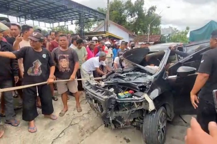 Warga mengevakuasi sopir Mitsubishi Xpander yang terjepit di dalam kabin usai adu banteng dengan truk ekspedisi di Jalan Raya Ponorogo-Pacitan, Desa Ngampel, Balong, Kabupaten Ponorogo, Jawa Timur.