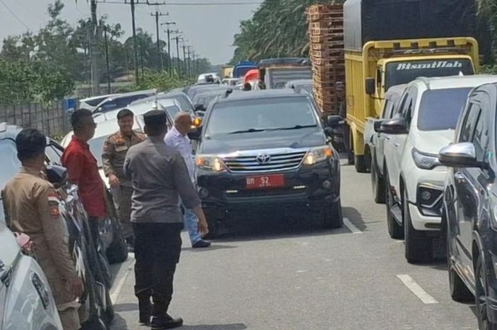 Toyota Fortuner berpelat nomor merah BM 52 menerobos antrean kemacetan jalan dengan melawan arus di kota Pekanbaru, Riau
