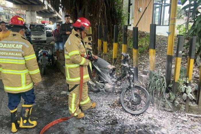 Suzuki Shogun disemprot busa pemadam kebakaran usai terbakar separuh di tepi Jl Kolonel Sugiono, Sukun, Kota Malang