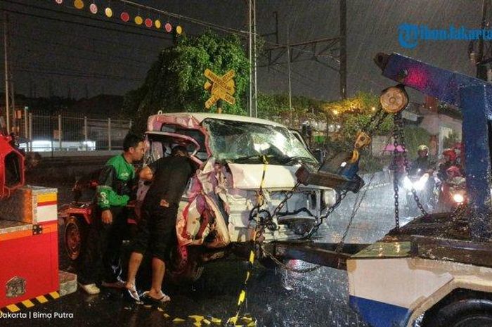 Suzuki Carry pikap yang menemper Kereta Api (KA) Barang di perlintasan Stasiun Pondok Jati, Matraman, Jakarta Timur