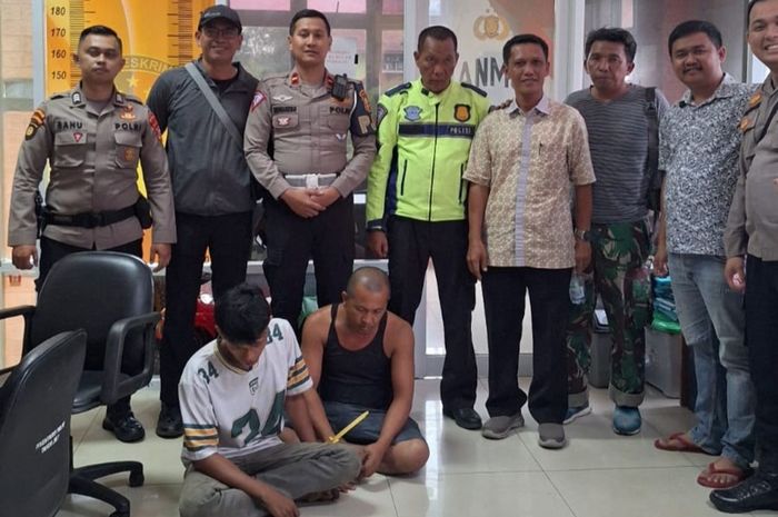 Dua awak truk berinisial DH (40) dan KW (26) duduk bersila di lantai setelah tertangkap mencuri tiang besi pembatas tol Tangerang-Merak