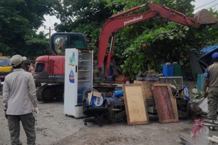 ekskavator obrak-abrik bangunan liar di dekat  jalan keluar-masuk Gerbang Tol (GT) Karawang Timur Tol Jakarta-Cikampek demi kelancaran arus mudik 2025