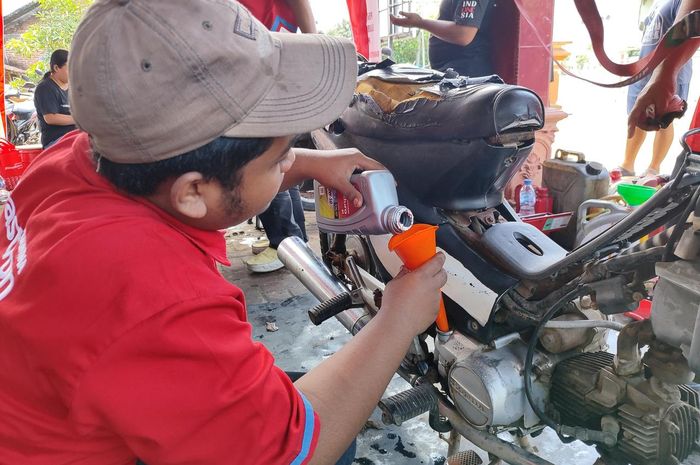 Ilustrasi proses ganti oli gratis dari Pertamina Lubricants untuk para korban banjir Jabodetabek