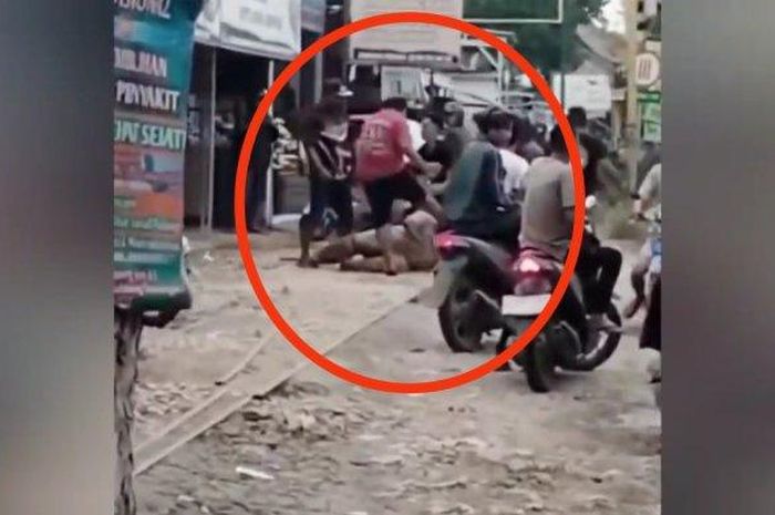 Dalam lingkaran merah, aksi pengeroyokan oleh banyak pemuda terhadap dua debt collector di tepi jalan raya Semarang-Purwodadi, Godong, kabupaten Grobogan, Jawa Tengah